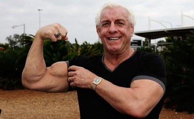 Ric Flair is showing off his muscles on his arm.
