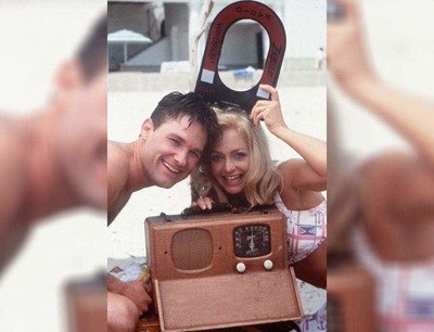 Kurt Russell and Goldie Hawn on the set of Swing Shift holding an old radio and magnets. 