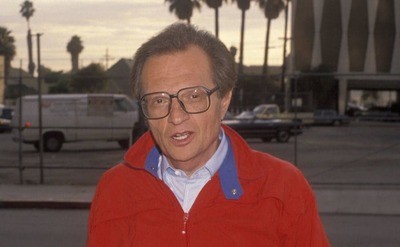 Larry King posing in front of CNN headquarters in 1990 