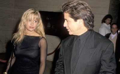 Pamela Anderson in a black dress and Jon Peters in an all-black tuxedo at a film premiere 