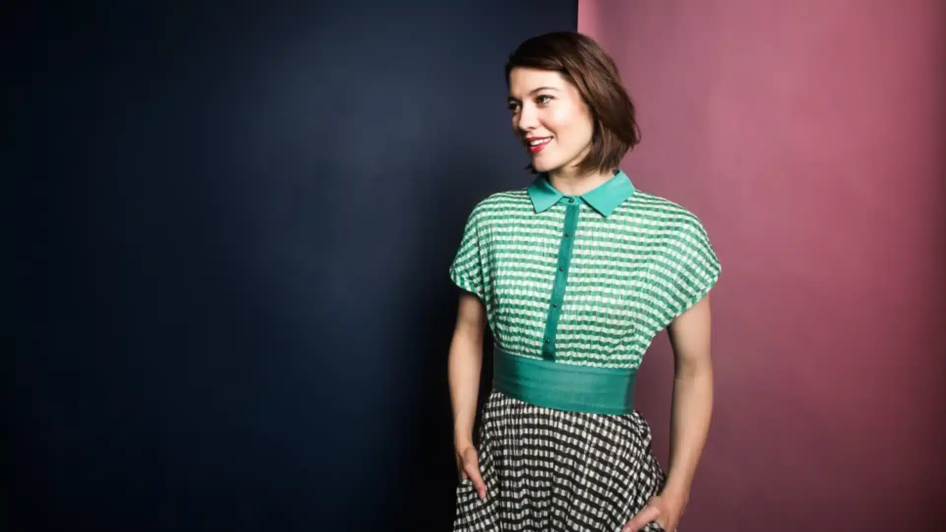 An image showing Mary Elizabeth Winstead's height wearing a green and white striped top and a black and white gingham skirt with brown hair