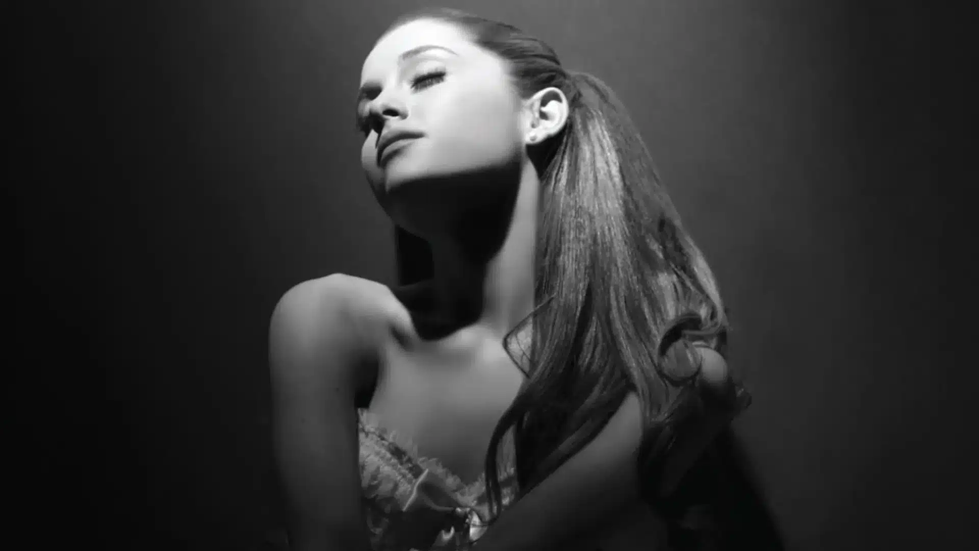 Black and white image of Ariana Grande's Yours Truly poster, showing her high ponytail and a dress