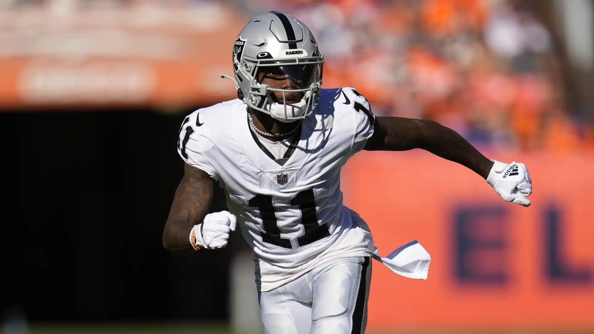 Henry Ruggs, playing football in the NFL, wearing a white jersey number 11, running on the field under bright daylight