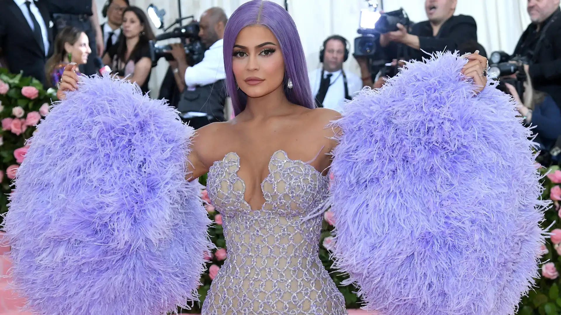 Kylie Jenner poses in a lavender, silver beaded gown with massive lavender ostrich feather sleeves on