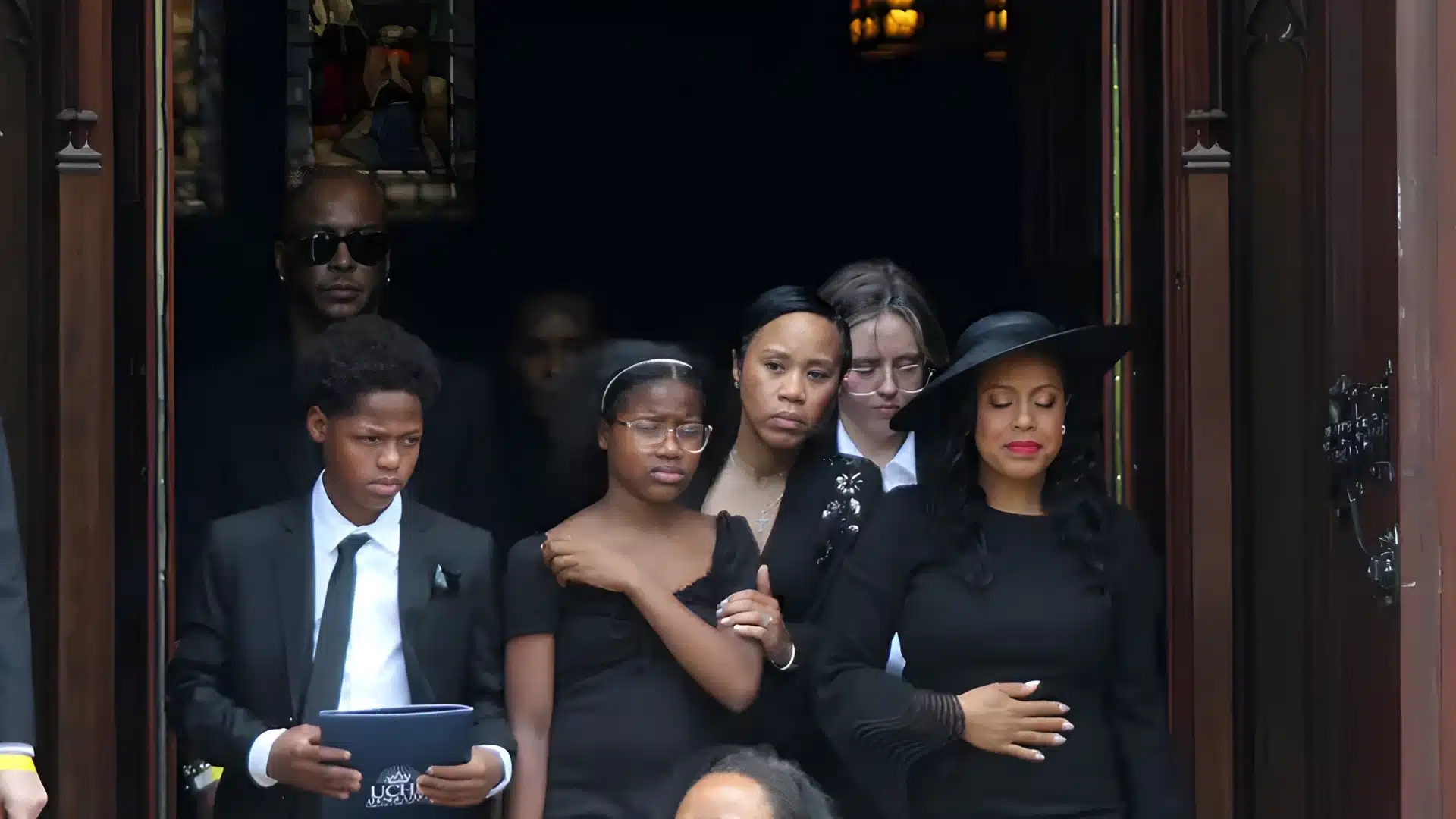 Sheinelle Jones and family at the funeral of Uche Ojeh, wearing all black and seen mourning