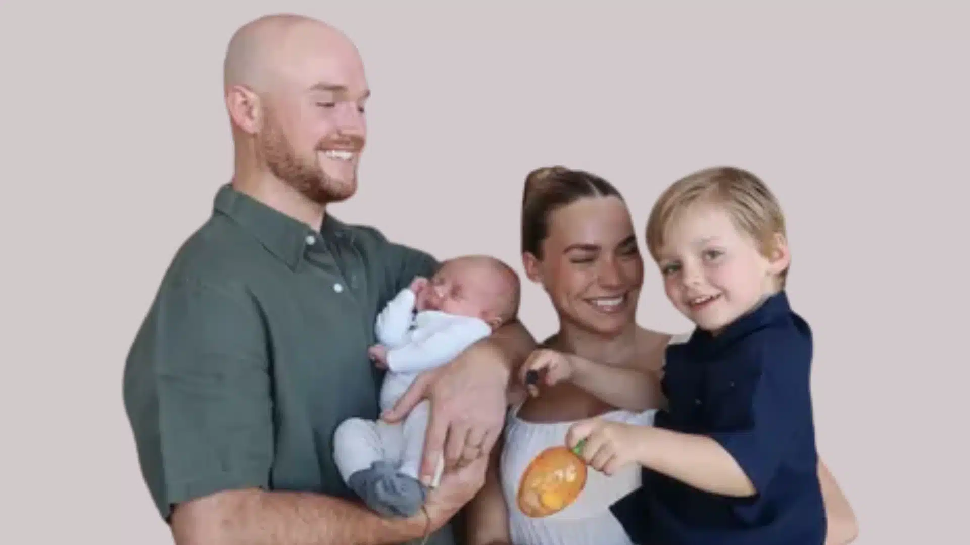 A family photo of Emilie Kiser's family, husband Brady Kiser, elder son Trigg, and younger son Theodre, against a pale background